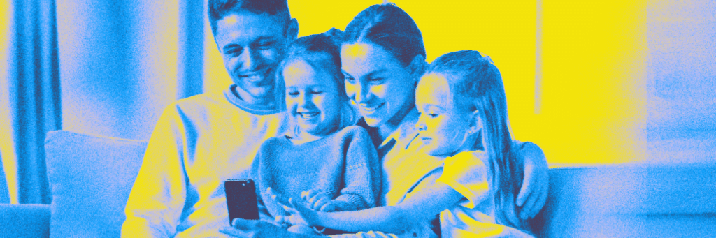 family smiling at a smartphone