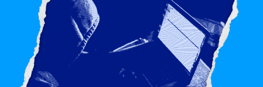 person in hoodie looking at laptop